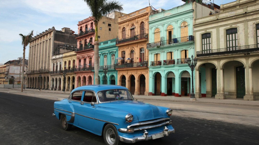 coche cubano en calle con casas coloridas